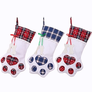 Three paw-shaped Christmas stockings with red and blue plaid accents for holiday decor