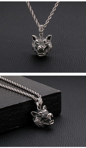 Detailed views of silver stainless steel wolf head pendant and twisted chain on leather