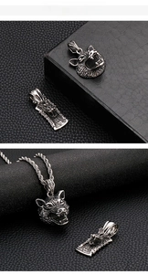 Close-up of vintage steel wolf head and dragon relief pendants with twisted chain