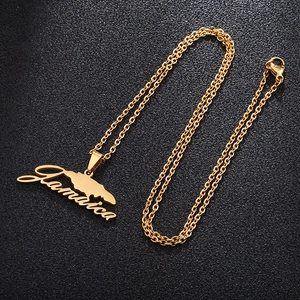 Detailed close-up of a gold Jamaica map pendant necklace with artistic text engraving