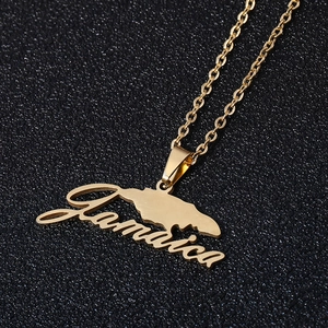 Golden Jamaica map pendant necklace with cursive text on a black sparkling background