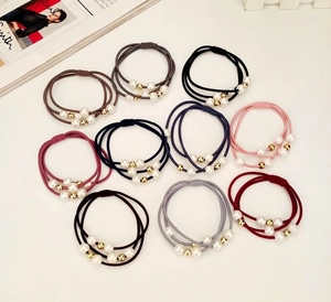 Detail view of 10 elastic hair ties with three-strand design and faux pearls