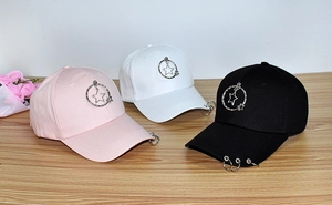 Detailed close-up of pink, white, and black baseball caps with silver star metal rings