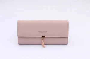 Detail of long mauve PU leather wallet featuring a leaf pendant and flap closure