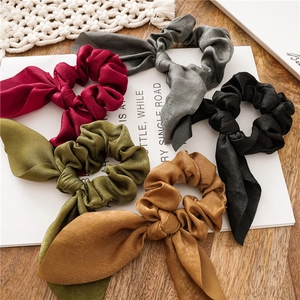 Detail of satin bunny ear scrunchies in burgundy, army green, camel, grey and black