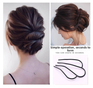 Close-up of a black 3-prong metal U-shaped hair pin for securing elegant bun hairstyles