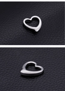 Detailed view of hollow heart pendant in stainless steel on black leather background