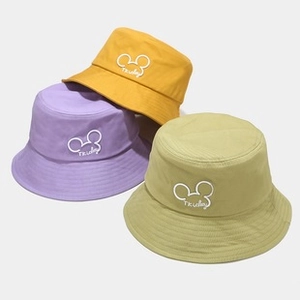 Dettaglio di cappelli bucket in cotone giallo, viola e verde con ricamo del personaggio