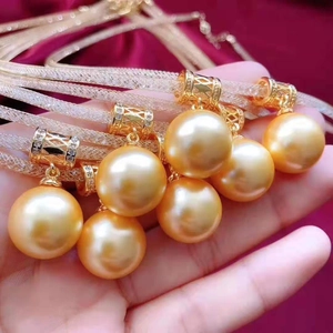 Close-up of golden South Sea pearls with diamond-set pendants on fine gold chains