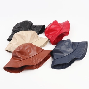 Flat lay of multiple PU leather bucket hats in black red beige brown and navy blue