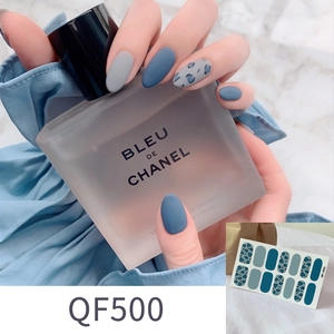 Makro-Detail von Leoparden-Nagelstickern und mattblauem Finish auf Modelhand