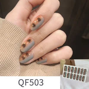 Makroaufnahme von Leoparden-Nagelstickern in Orange und Grau mit Goldfolien-Detail