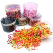 Detailed view of colorful elastic rubber hair bands stored in transparent plastic jars