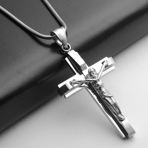 Detailed macro view of silver layered crucifix cross pendant on a snake chain necklace