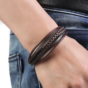 Men's multi-layer dark brown hand-woven leather bracelet on model wearing denim jeans