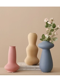 Jarrones minimalistas de cerámica en rosa, beige y azul con acabado mate y flores