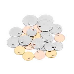 Pile of round stainless steel blank pendants in gold, silver, and rose gold with small holes