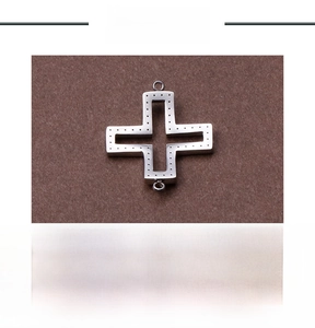 Macro detail of hollow cross pendant in stainless steel showing intricate metal texture