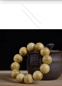 Detailed view of 108 Papua sandalwood prayer beads next to a traditional teapot