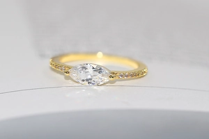 Macro detail of marquise-cut zircon ring with 14k gold plating and pavé-set stones