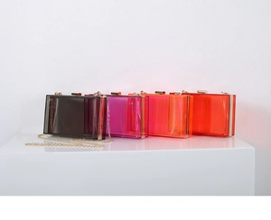 Detailed view of clear acrylic evening clutch bags in four colors with gold chain straps