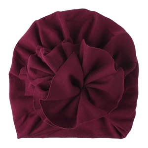 Detailed close-up of wine red baby turban hat with large 3D flower and knit texture