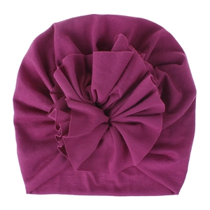 Macro detail of the pleated fabric and large 3D flower on the purple baby turban hat