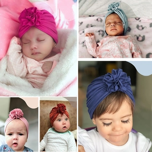 Detailed view of baby turban hats with ruffled flower designs in various colors