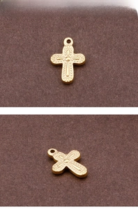 Detailed macro view of a golden metal cross pendant with embossed sunburst texture