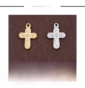 Detailed view of 2g stainless steel cross pendants with textured dot pattern