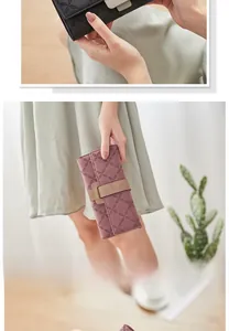 Detail of clover embossed pattern and metal buckle on matte leather long wallet