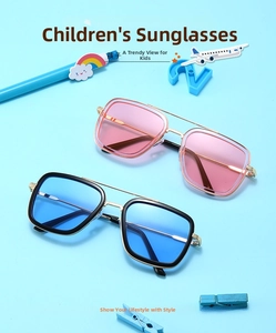 Detail of stylish kids' metal sunglasses with pink and blue tinted lenses on blue background