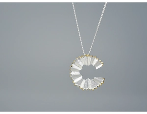 Detail shot of the creative S925 silver pencil shaving pendant with gold-plated edges