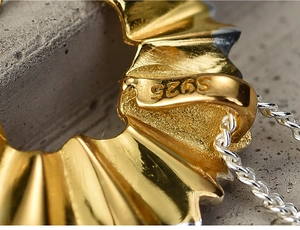 Macro shot of S925 sterling silver pencil shavings pendant detail with hallmark