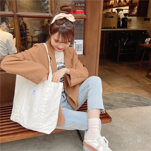 Lifestyle shot of an off-white canvas tote bag showing interior storage and casual use