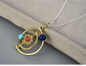 Macro detail of solar system necklace with colorful natural stone planets and golden orbits