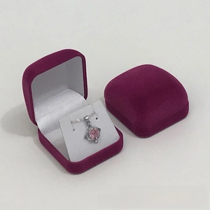Macro shot of purple velvet jewelry box set with pink gemstone necklace inside