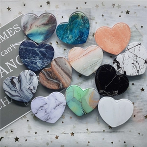 Flat lay of 12 heart-shaped phone sockets with marble textures and solid pastel colors