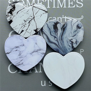 Detailed view of four heart-shaped marble pattern collapsible phone grips in various colors