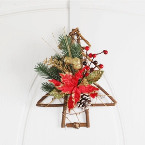 Christmas tree wreath with red poinsettia and pine cones on a white wooden door