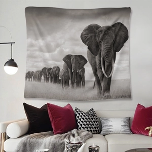 Bohemian black and white elephant migration tapestry hanging on wall above a sofa
