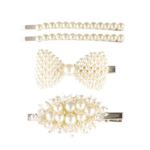 Close-up of a four-piece pearl hair clip set with bow and cluster designs on silver base