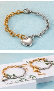 Détail d'un bracelet bicolore or et argent avec pendentif cœur poli et maillons