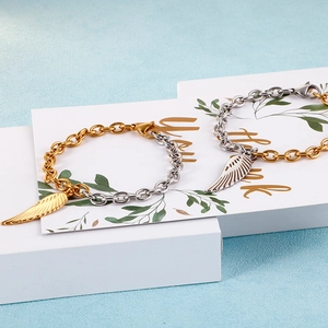 Two-tone silver and gold stainless steel feather charm bracelet with o-chain link