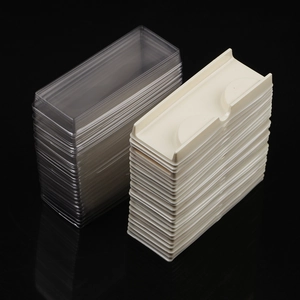 Macro shot of 60-piece clear plastic lids and beige bases for eyelash packaging boxes