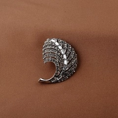 Close-up of a silver eagle brooch with sparkling rhinestones on dark fabric