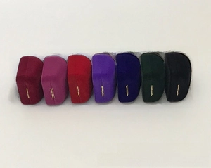 Row of seven colorful velvet jewelry boxes with gold hinges for rings and earrings