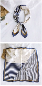 Detail of navy and beige striped square silk scarf with gold star patterns and elegant knot