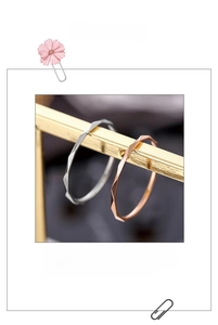 Detail of rose gold and silver V-shaped rings with faceted cut textures on metal bars