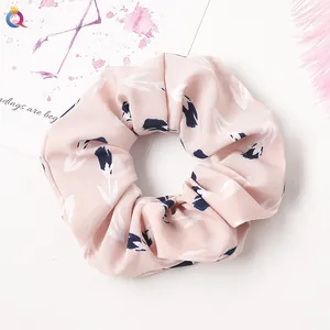 Detail of floral scrunchie in light pink with abstract blue pattern and smooth texture